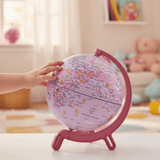 A child's hand spinning the small 6-inch Giacomino pink globe.